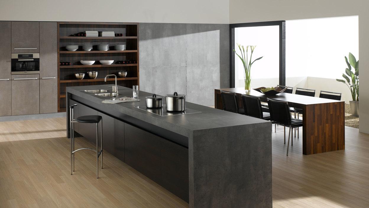 Küchen- und Esszimmerimpression mit einer Kombination aus Holz- und Stein-/ Betonoptik und Einbauschränken