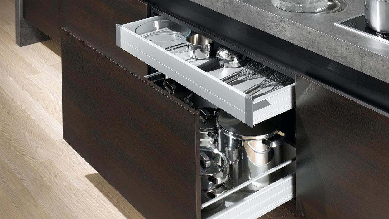 Detailaufnahme von Küchenschubladen Detailaufnahme von Küchenschubladen mit viel Stauraum in dunklem Holz