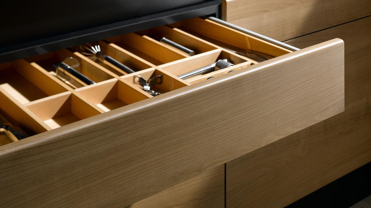 Detailaufnahme einer Besteckschublade aus hellem Massivholz