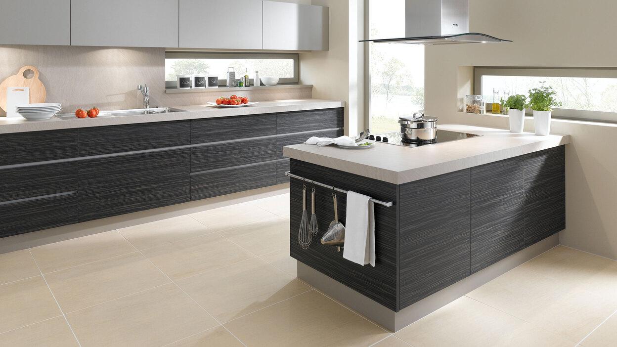 Impression einer Küchengestaltung mit Kochinsel Impression einer Küchengestaltung mit Kochinsel mit Edelstahlabzug und dunklen Fronten