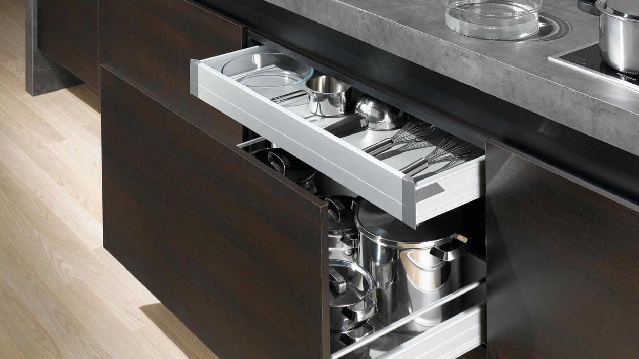 Detailaufnahme von Küchenschubladen mit viel Stauraum in dunklem Holz