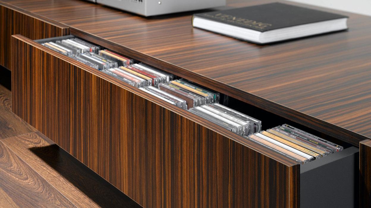 Detailaufnahme eines lackierten Sideboards mit offener Schublade für CD-Aufbewahrung